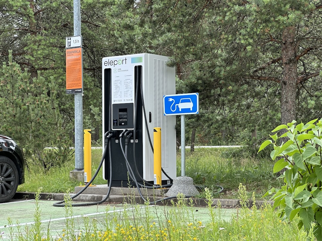 Foto auto parkimiskohast, mille kõrval on elektriautodele mõeldud kiirlaadija.